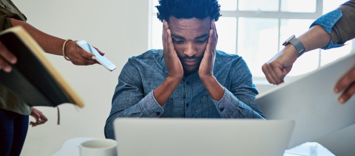 Shot of a stressed out young man working in a demanding career